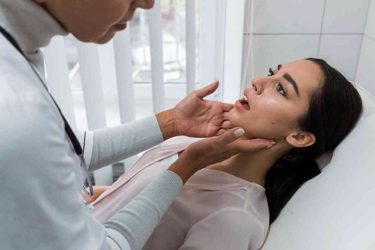 Doctor examining patient’s jaw and mouth in clinic